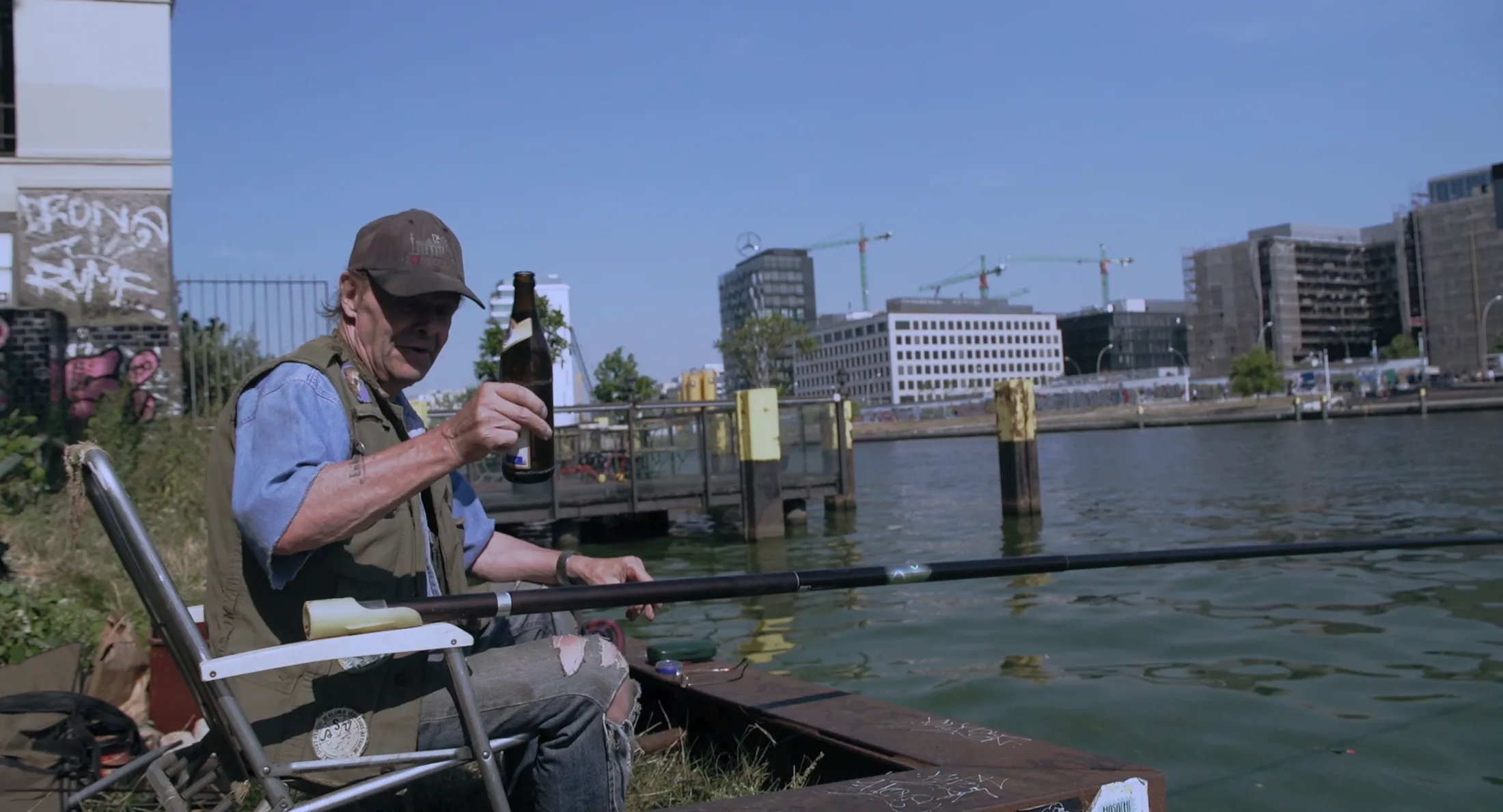 Will drinks his beer by the River Spree in the Kiez documentary